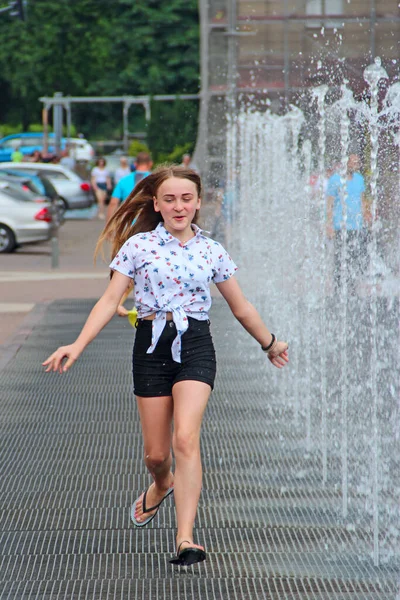 小女孩在喷泉里玩乐 城市炎热的夏季天气 在炎热的天气里 小女孩在泉水边跑 儿童在喷泉的水柱之间奔跑 — 图库照片