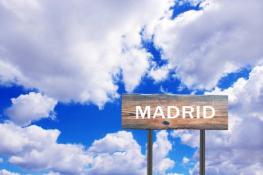 Gökyüzü manzaralı Madrid yazısıyla imzalayın. Yerleşim yerinin göstergesi. Yol tabelası yerleşim yerini gösteriyor. Madrid 'in mavi ve bulutlu arkaplanını imzalayın