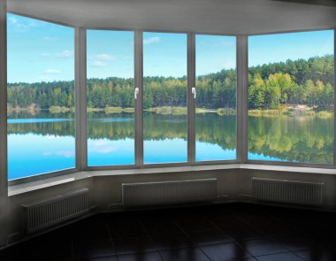 Orman Gölü 'nün panoramik manzaralı büyük pencereli odası. Ormanda göl manzarası. Oda penceresinden doğaya panoramik bir bakış. Açık pencereden görüntüle. Modern tasarım. Çam ağaçları
