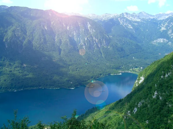 landscape with mountain lake and sunny rays. Landscape with mountain valley and lake. Mountains covered with forest and lake. Mountain panorama with forest and river. Bright day in mountains
