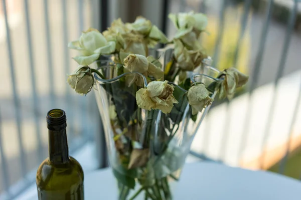 Vissnade Gula Rosor Och Vin Flaska Bordet — Stockfoto