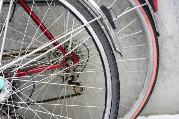Gri bir duvara park etmiş iki vintage Bisiklet arka tekerlek