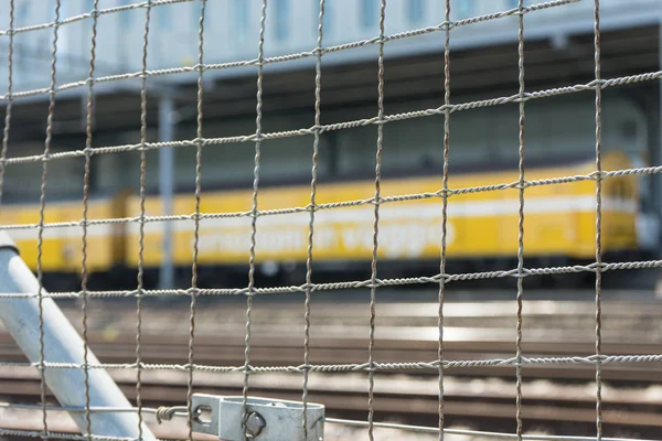 Trem Amarelo Visto Através Cerca Ferro Cinzento Com Trilhos — Fotografia de Stock