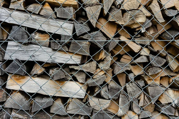 fire wood stack piled up behind fence
