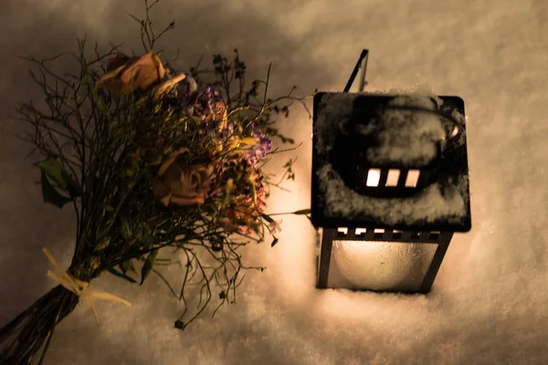 Buquê de flores com lanterna na neve — Fotografia de Stock