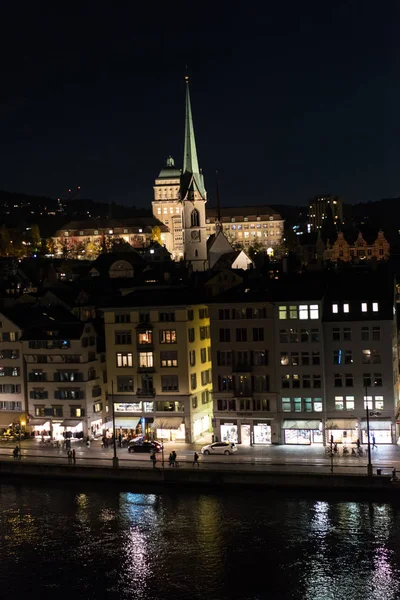 Kota Zurich pada malam hari dengan gereja dan gedung universitas — Stok Foto