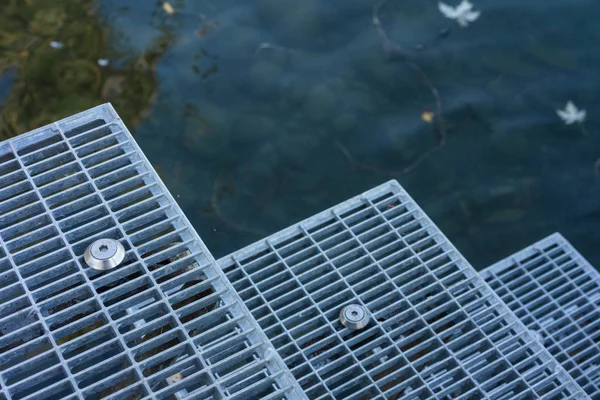 Металлическая лестница в воду для купания — стоковое фото