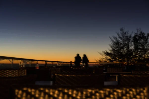 Casal romântico ao pôr do sol visto de longe Imagem De Stock