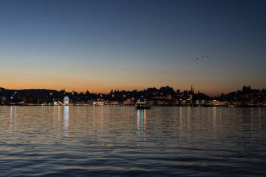 şehir panoraması ve İsviçre 'de su yansıma popüler turist hedef ile göl Lucerne gün batımı
