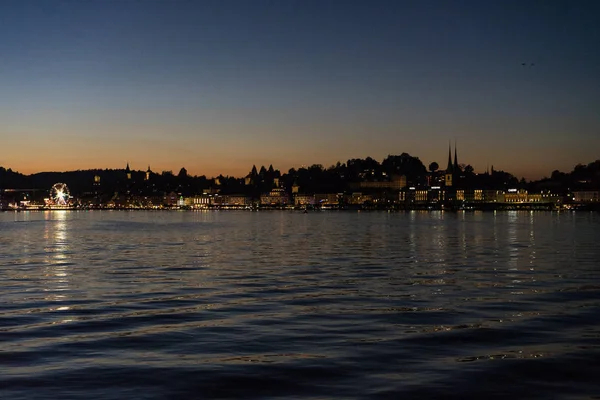 Matahari terbenam di danau lucerne dilihat dari perahu dengan latar belakang kota — Stok Foto