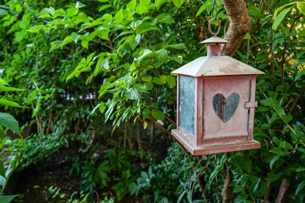 Klein huisje decoratie met hartvormige venster in tuin — Stockfoto