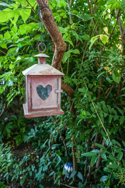 Klein huisje decoratie met hartvormige venster in tuin — Stockfoto