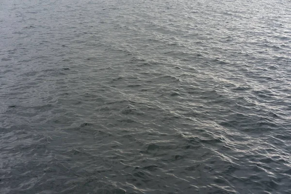 Fundo - água do lago com ondas em um dia nublado — Fotografia de Stock