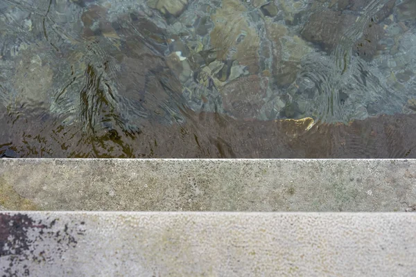 Спускайтесь по бетонной лестнице в воду, концептуальная фотография — стоковое фото