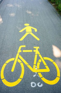 Sarı bisiklet ve yaya caddesi üzerinde işaretler