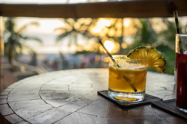 Bevande tropicali sul tavolo con palme sullo sfondo — Foto Stock
