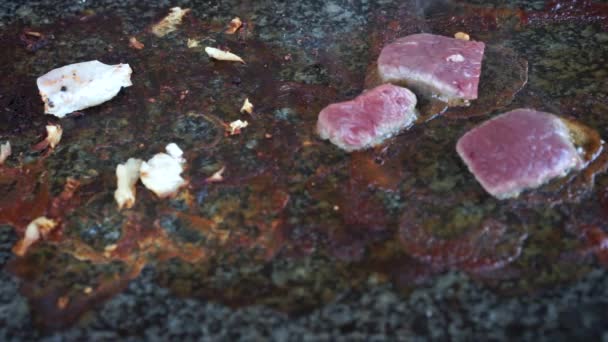 Cozinhar carne crua na mesa de pedra quente grill vídeo — Vídeo de Stock