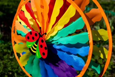 windmill spinning in wind on green nature background.decoration element in garden. Kids colorful windwill. bright nature background.