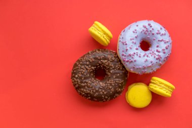 Acıbadem kurabiyesi ve çörek kırmızı zemin üzerine Dikişsiz desen yaptı. Düz yatıyordu. Gıda kavramı. Sağlıksız tatlı. lezzetli tatlı sabah. Çörek ve izole Fransız lezzetli kek