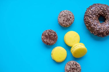 Renkli macarons kek, üstten görünüm düz yatıyordu, şeker mavi zemin üzerine tatlı acıbadem kurabiyesi. En az kavramları desen yukarıda, gıda arka plan. Fransız tatlı tatlı ve bir çörek. Kopya alanı