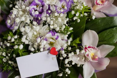 Çiçek hediye boş kartı tebrik kartı kavramı ile. Üstten görünüm, yakın çekim. Orkide sevilen ones.bouquet için tebrikler. Düğün davetiye veya aşk mektubu