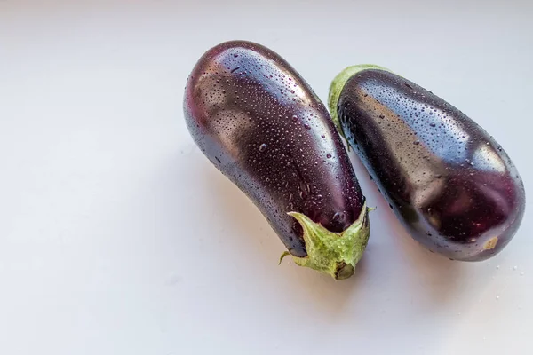 Verse aubergine met druppels op wit wordt geïsoleerd. Gezond eten concept. Paarse rijp aubergine met waterdruppels. Vegan plantaardige. Dieetvoeding. Kopiëren van ruimte — Stockfoto