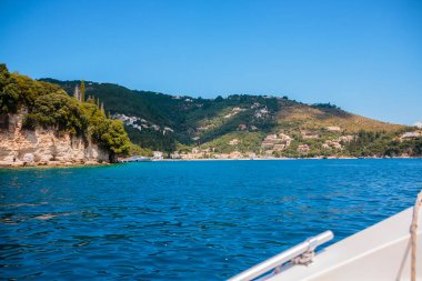 Rock kayalıklarla ve beyaz evler, Yunanistan Island'deki/daki oteller ile plaj manzarası. Corfu. Avrupa seyahat. Tekne görüntüleyin. Deniz manzarası ve güzel deniz tatil. Kopya alanı
