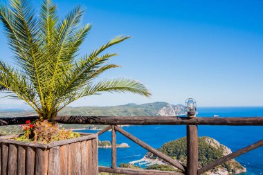 Koyu ve Plajı Paleokastritsa çiçekli görüntüleyin, palmiye ağacı ve mavi deniz suyu Korfu Adası, Lakones noktasında Greece.View. Kopya alanı