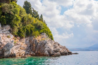 Güzel ve renkli kaya kıyı şeridi ve görünümünü kristal, güneşli mavi deniz. Küçük taş cliff turkuaz su tatil gezisi sırasında içine atlamak için ideal.