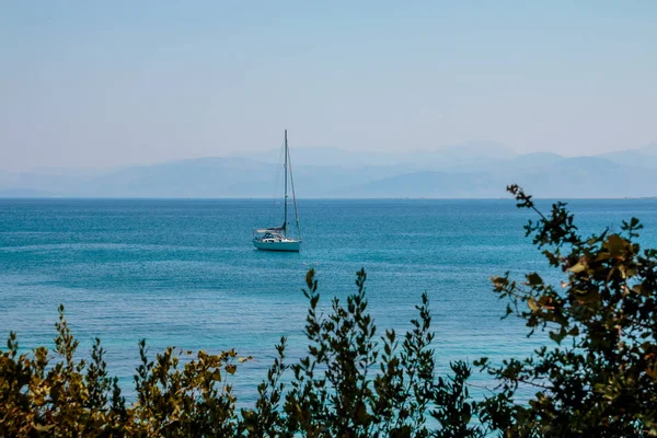 Navegar por el mar Jónico en Grecia. Yate de lujo cerca de la costa. Agua azul clara. Vacaciones de mar en Europa. Hermosa vista de la costa rocosa y el cristal, mar azul en el día soleado . — Foto de Stock