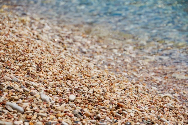 Pebble stenen door de zee. Zijdeachtige golven van blauwe sea.beach stenen op de kust. Kustlijn — Stockfoto