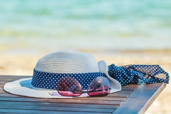 Sunprotection objects on the beach in holiday sunglasses and white hat. Leisure in summer with copy space. Minimal style.Summer flat lay scenery.beach accessories on turquoise tropical background — Stock Photo, Image
