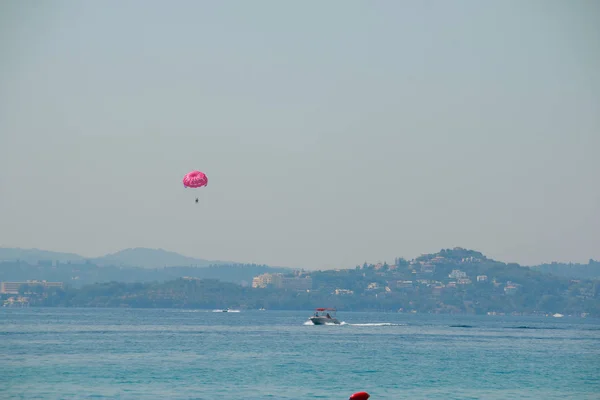 Parasailing ist ein beliebter Sport in vielen Resorts auf der ganzen Welt. die aktive Form der Entspannung. Touristen am Fallschirm hinter einem Boot. Strandurlaub. Unterhaltung auf See — Stockfoto