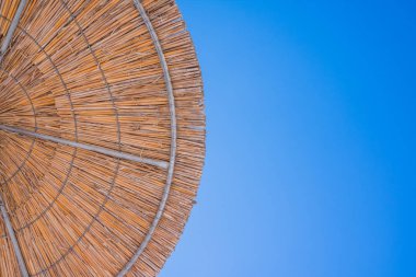 Mavi gökyüzü güneş şemsiyesi saman çatısı. Tatil topic.summer beach, bir yazıt için arka plan. Saman bir tropikal çöl tatil yapılan güzel saman doğal güneş şemsiyesi dokusuna,