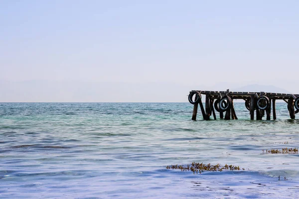 Hermoso puerto deportivo en la orilla de la naturaleza del fondo del mar. Antiguo muelle de madera en la costa del mar, sobre fondo de cielo claro. Copiar espacio — Foto de Stock