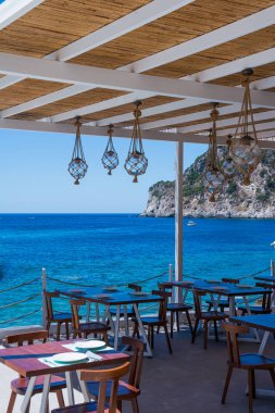 Deniz görünümü restoran yaz Pavilion ya da teras iç ile açılan kayar pencere eşiği, modern lambalar, parke döşeme ve ahşap Furniture.Vertical resim