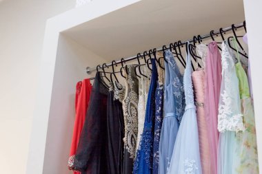 askı elbise üzerinde uzun elbiseler Akşam dükkanı düğün günü veya fotoğraf oturumu için kira. Seçici odak. Topu cüppe Kiralama kavramı. Moda olay. Elbise Servisi, moda endüstrisinin kira. Elbise kiralamak