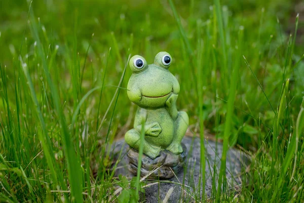 装饰迷你青蛙。花园里草地上的小滑稽的青蛙雕像。复制空间。绿青蛙的绿色陶瓷图。装饰元素. — 图库照片