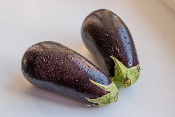 Fresh juicy organic eggplants with green leaves. Isolated on white background.Vegan vegetable. Diet food.Copy space — Stock Photo, Image