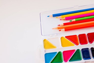 Metin, tasarım için bir yer. Sanatçı çizim için çalışma alanı. Renkli kalem, suluboya, boyalar, beyaz arka plan masaya izole kağıt. Eğitim kavramı.