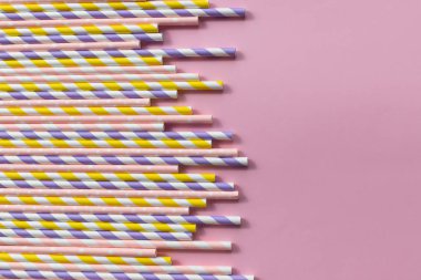 parti için pembe arka plan üzerinde renkli kağıt çöp. Renkli içme strawsisolated. İçme suyu veya meşrubat için kullanılan kağıt çöp bir renkli soyut. Kopya alanı