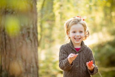 Doğa üvez meyveleri ile güzel saç modeli ile şirin kız. Rüya gibi genç sarışın kız elele üvez meyveleri ve dikkat et. Sonbahar park.happy sonbahar. Kopya alanı