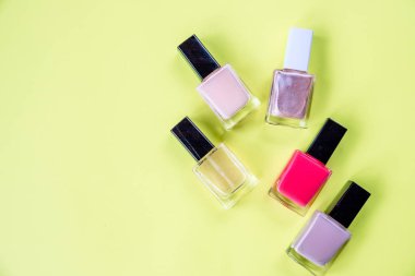şişe tırnak cilası sarı arka plan en iyi view.hands bakım kavramı ile tırnak cilası sarı Resepsiyon arka plan üstten görünüm mock-up sürü. Kopya alanı