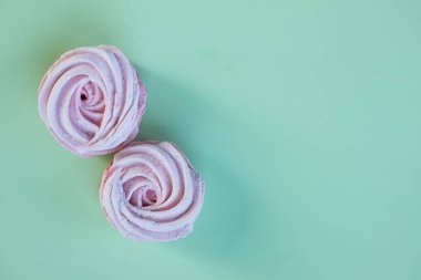 Pembe ev yapımı Marshmallows veya Zephyr. Tatlı, şeker çöl üzerinde pastel yeşil arka plan. Şekerli kurabiye. Uzay kopyalayın. Berry kümesi sufle, ev yapımı beze.