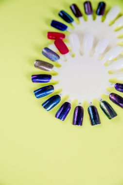 Renkli çivi sarı zemin üzerine manikür için palet Lehçe. Çivi renk Lehçe örnekleri, üstten görünüm koleksiyonu. Tırnak sanat wheel.manicure. Parlak jel lacquer.design tekerlek. Kopya alanı.