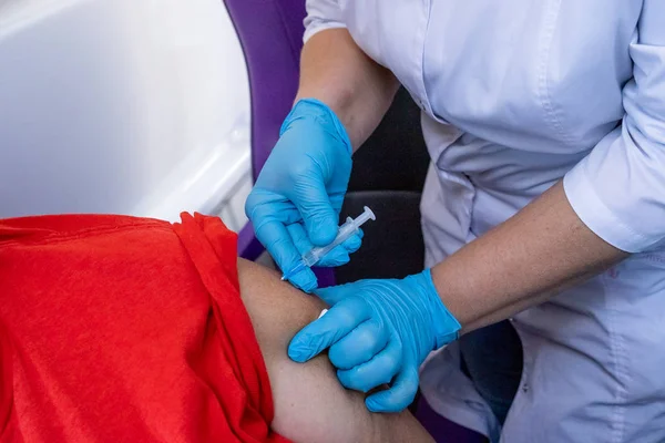 Mavi eldiven akes aşı omuz hastanın hastanede doktor. Profilaksi ve bulaşıcı ve viral hastalıkların tedavisinde. Aşı Grip karşı. Kuduz karşı aşı.