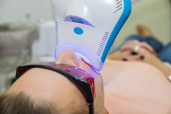 Kadın için diş beyazlatma. Dişçi klinikte diş beyazlatma. Diş ultraviyole lamba doldurma. Yordam ultraviyole ışık Uv lambası ile diş beyazlatma.