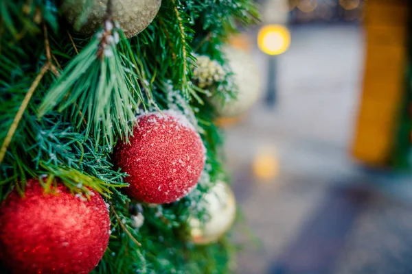 Atmosfera familiare natalizia.Ornamento natalizio rosso e dorato appeso a un pino coperto di gelo all'aperto con spazio per copiare.Decorazione natalizia con molte luci. — Foto Stock