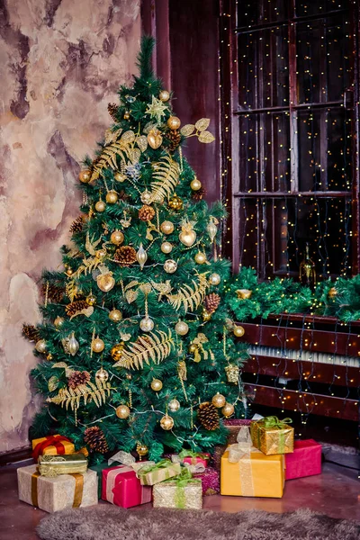 Decorado festivamente interior de la casa con el árbol de Navidad. cajas de regalo bajo el árbol de Navidad. Coloridas cajas de regalo amarillas y rojas, doradas con lazo de cinta presente en vacaciones.Concepto de tarjeta postal.Espacio de copia —  Fotos de Stock