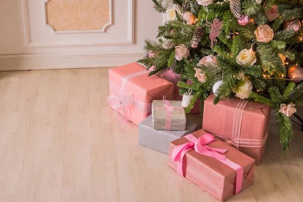 Pastel Noel. Dekorasyon ve zarif ahşap döşeme hediyeler ile zarif Noel ağacı. Pembe Noel hediye kutuları yanında pembe ve gümüş kurdele ile süslenen Noel ağacı. Pembe, yumuşak şeker